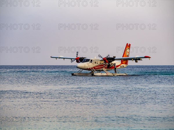 Seaplane landing in a lagoon of a Maldives island