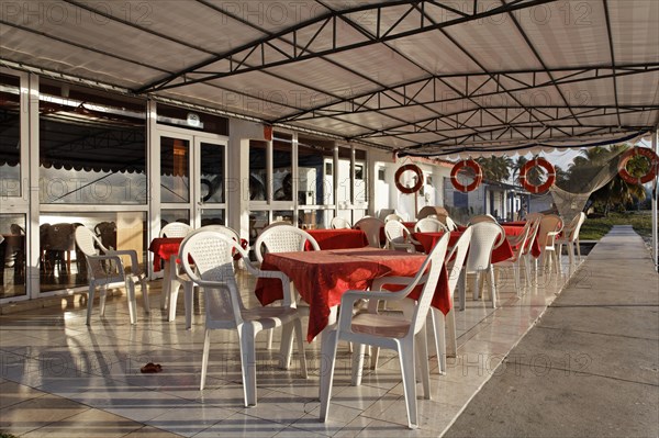 Terrace in front of restaurant with plastic chairs