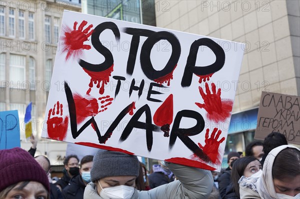 Female protestor holds protest poster against the Russian invasion of Ukraine