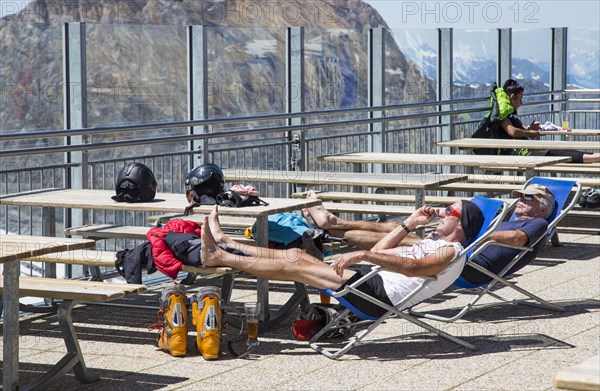 Two skiers sunbathing