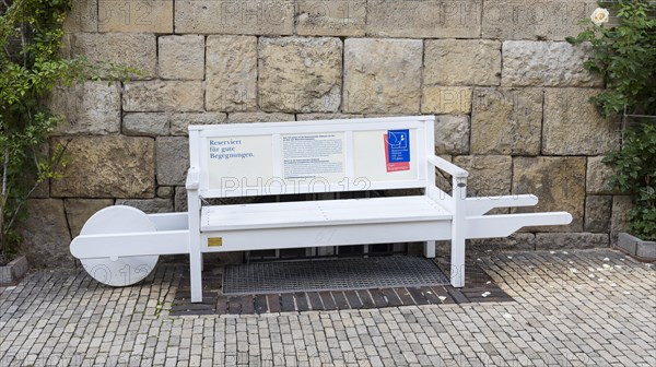 White bench in the shape of a wheelbarrow