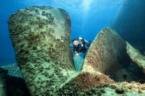 Diver looks down on giant propeller from sunken shipwreck Astron