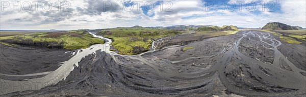 River with fanned out branches through black lava sand