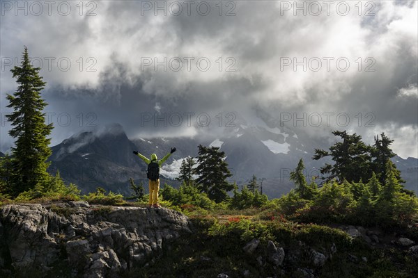 Hiker stretches his arms in the air