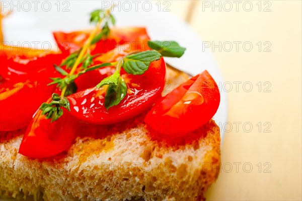 Italian tomato bruschetta with thyme and mint leaves