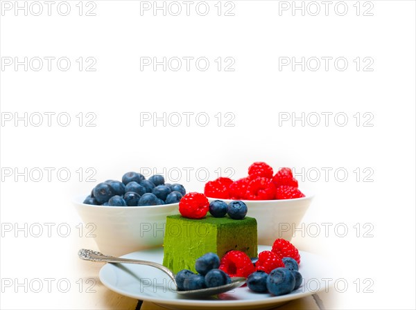 Green tea matcha mousse cake with raspberries and blueberries on top