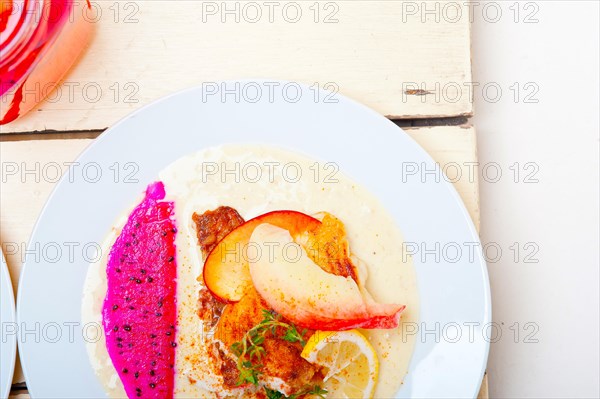 Sea bream orata fillet butter pan fried with fresh peach prune and dragonfruit slices thyme on top