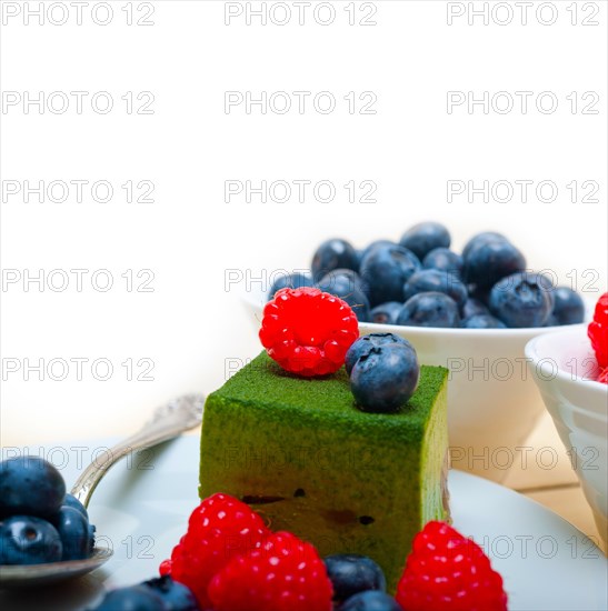 Green tea matcha mousse cake with raspberries and blueberries on top