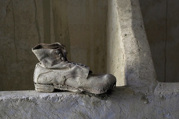 Leather work shoe on wall