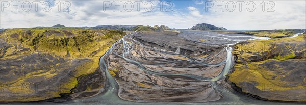 River with fanned out branches through black lava sand