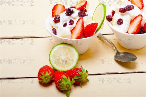 Fruit and yogurt salad healthy breakfast over white wood table