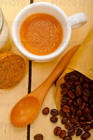 Espresso coffee and beans on a paper cone cornucopia over white background