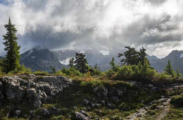 Hiker in front of cloudy Mt. Shuksan with snow and glacier