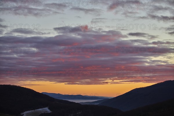 Fog lying in a valley at sunset