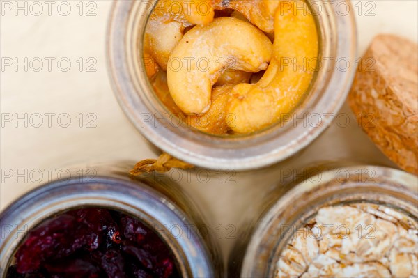 Healthy breakfast ingredients milk oat cashew nuts dried cramberry craisinns