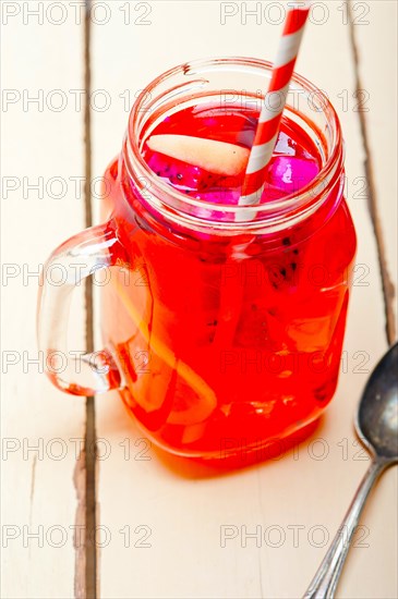 Fresh fruit punch refreshing summer drink over white rustic wood table