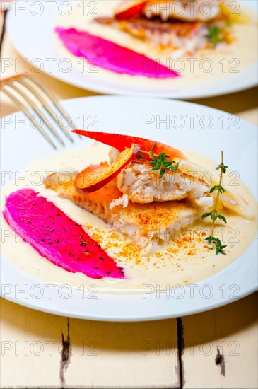 Sea bream orata fillet butter pan fried with fresh peach prune and dragonfruit slices thyme on top