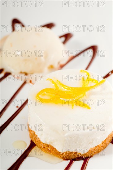 Very elegant lemon mousse dessert served whith lemon peel on top and vanilla ice cream on side