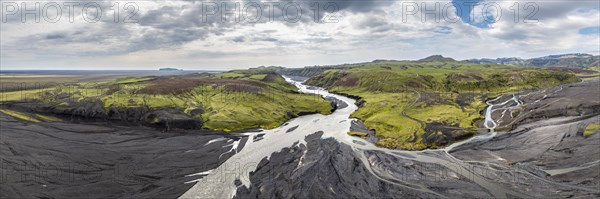 River with fanned out branches through black lava sand