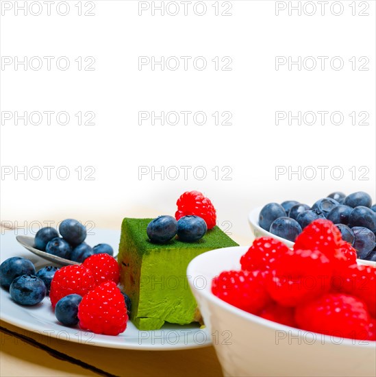 Green tea matcha mousse cake with raspberries and blueberries on top