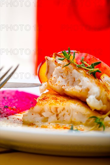 Sea bream orata fillet butter pan fried with fresh peach prune and dragonfruit slices thyme on top