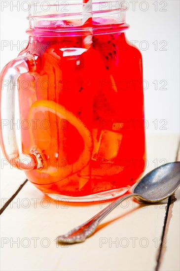 Fresh fruit punch refreshing summer drink over white rustic wood table