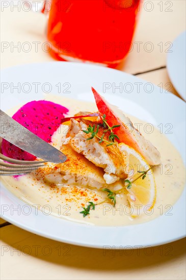 Sea bream orata fillet butter pan fried with fresh peach prune and dragonfruit slices thyme on top