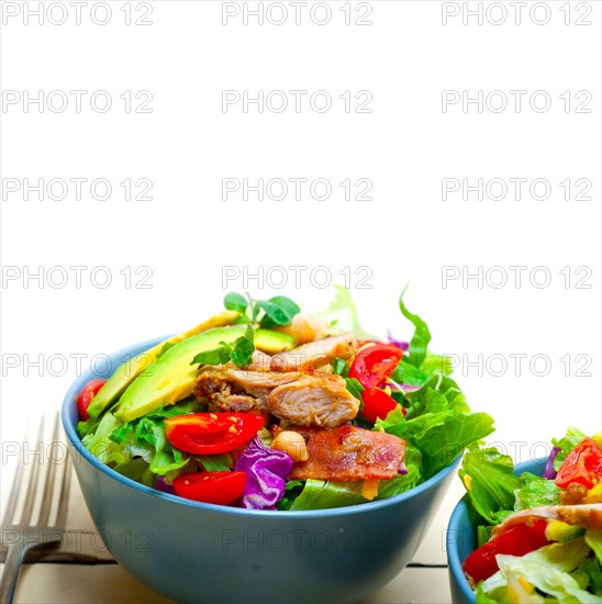 Fresh and healthy Chicken Avocado salad over rustic wood table