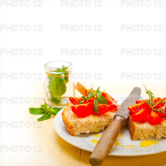 Italian tomato bruschetta with thyme and mint leaves