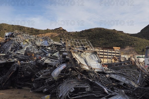 Scrap pile with metal linkage in front of hill