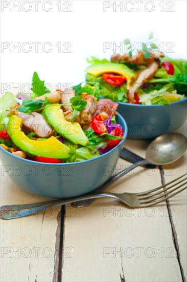 Fresh and healthy Chicken Avocado salad over rustic wood table