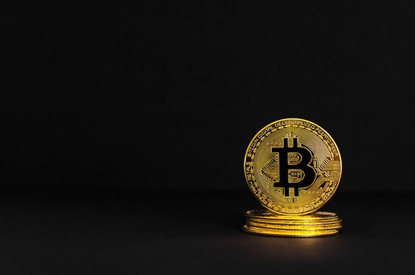 Bitcoin BTC crypto currency gold coins on black background