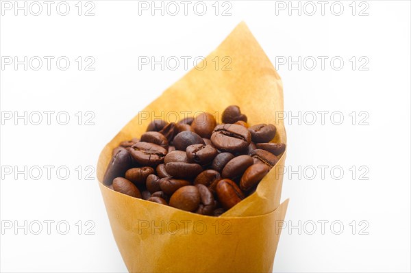 Espresso coffee beans on a paper cone cornucopia over white background