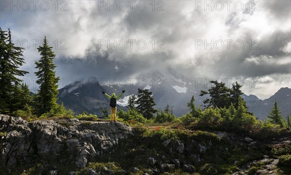 Hiker stretches his arms in the air