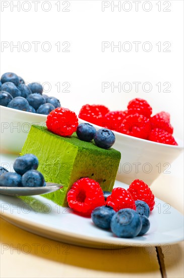 Green tea matcha mousse cake with raspberries and blueberries on top