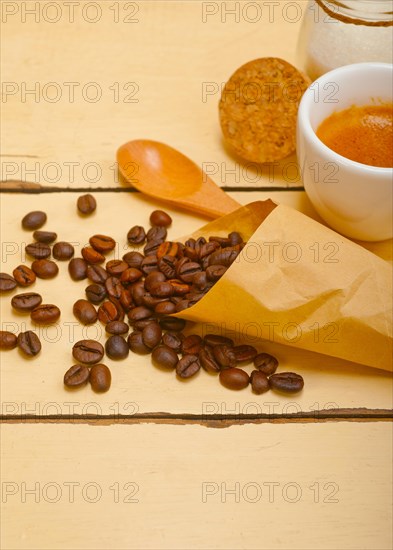 Espresso coffee and beans on a paper cone cornucopia over white background