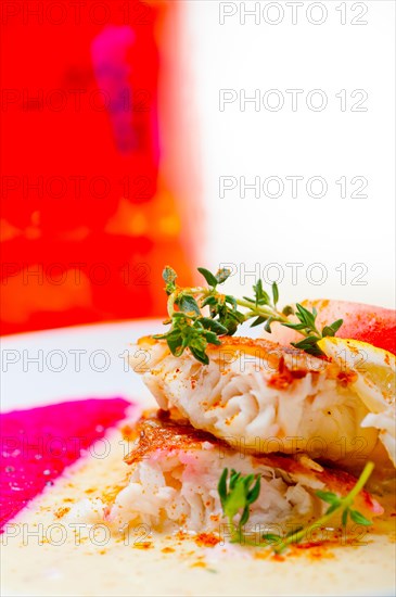 Sea bream orata fillet butter pan fried with fresh peach prune and dragonfruit slices thyme on top