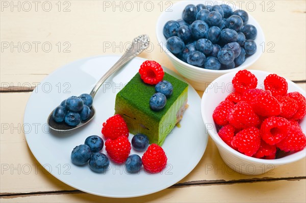 Green tea matcha mousse cake with raspberries and blueberries on top