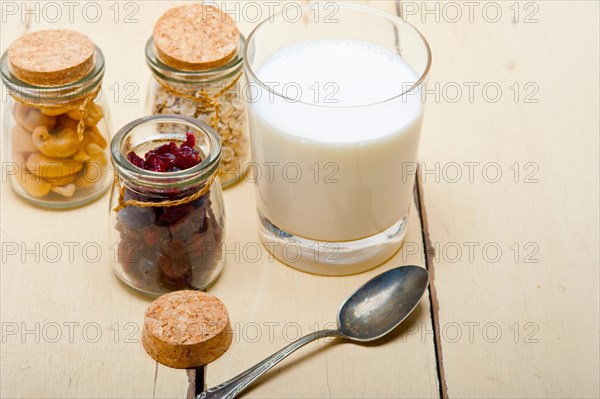 Healthy breakfast ingredients milk oat cashew nuts dried cramberry craisinns