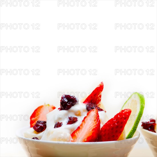 Fruit and yogurt salad healthy breakfast over white wood table