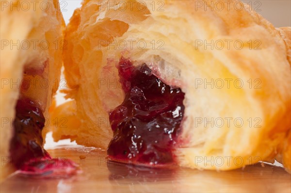 Fresh baked croissant French brioche filled with berries jam