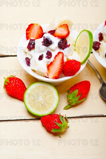 Fruit and yogurt salad healthy breakfast over white wood table