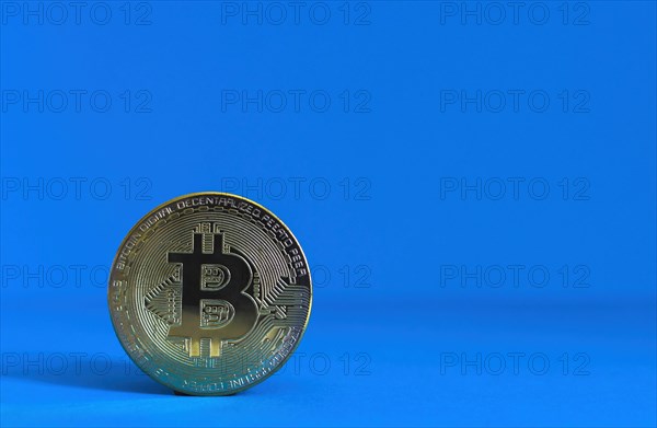 Bitcoin BTC crypto currency gold coin on blue background