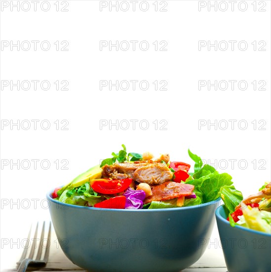 Fresh and healthy Chicken Avocado salad over rustic wood table