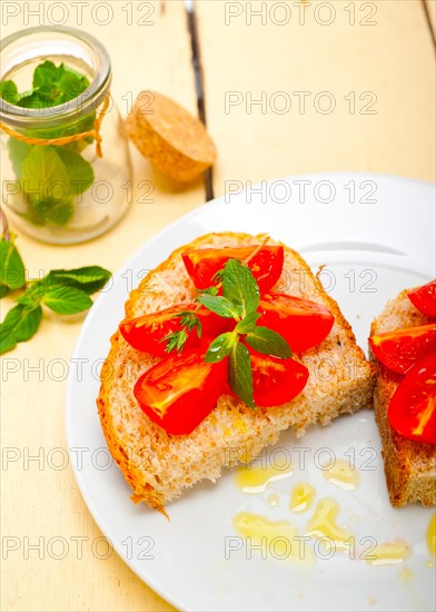 Italian tomato bruschetta with thyme and mint leaves