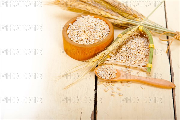 Organic wheat grains over rustic wood table macro closeup