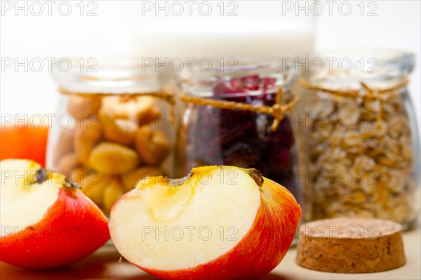 Healthy breakfast ingredients milk oat cashew nuts dried cramberry craisinns