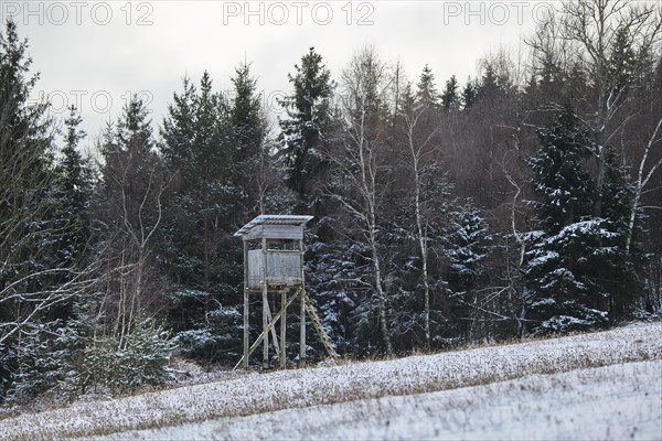 Hunters blind in a snowy landscape next to the forest
