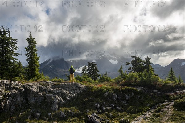 Hiker in front of cloudy Mt. Shuksan with snow and glacier