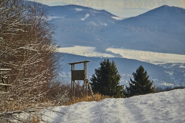 Hunters blind in a snowy landscape next to the forest